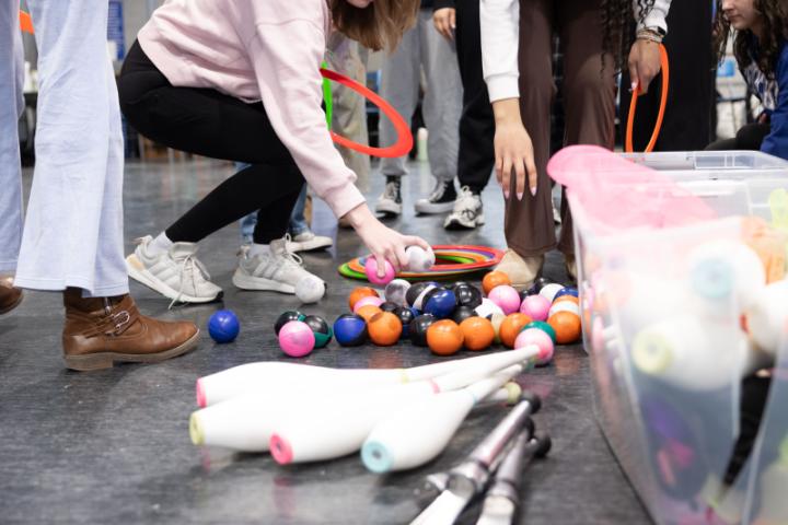 Students grabbing juggling supplies