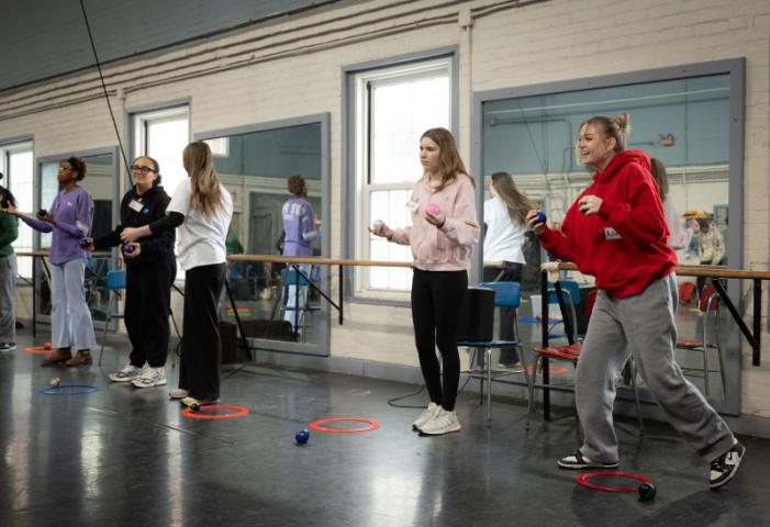 Five students attempting to juggle and laughing