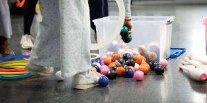 Student reaching in a bin of juggling balls